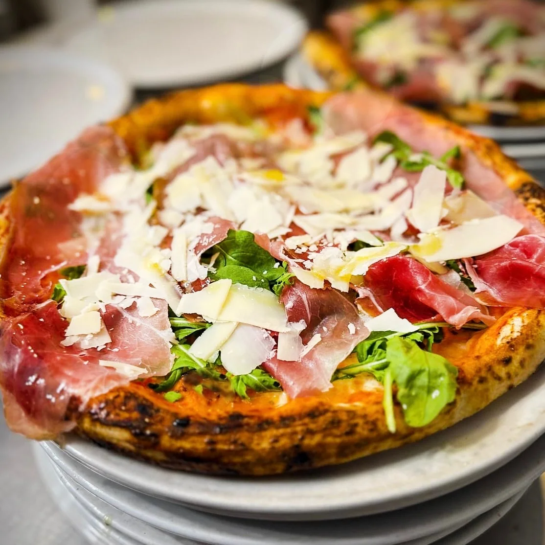 Pizza con prosciutto crudo, rucola e scaglie di formaggio da VIBES